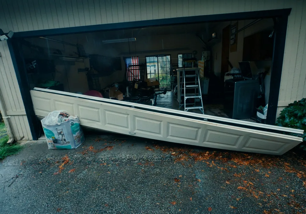 Storm-damaged garage door pulled out of its opening