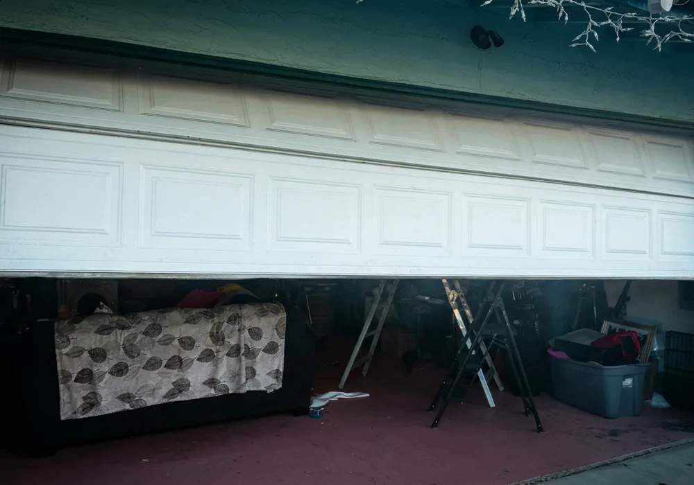 Sagging garage door on a teal stucco home